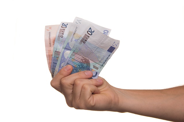 ruka drží vějíř eurových bankovek